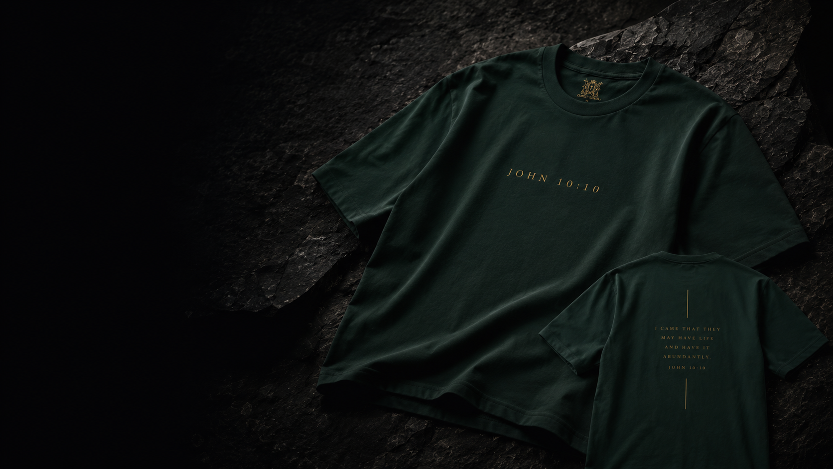 Front and back views of the dark green John 10:10 Christ Scouts T-shirt on a rocky background.